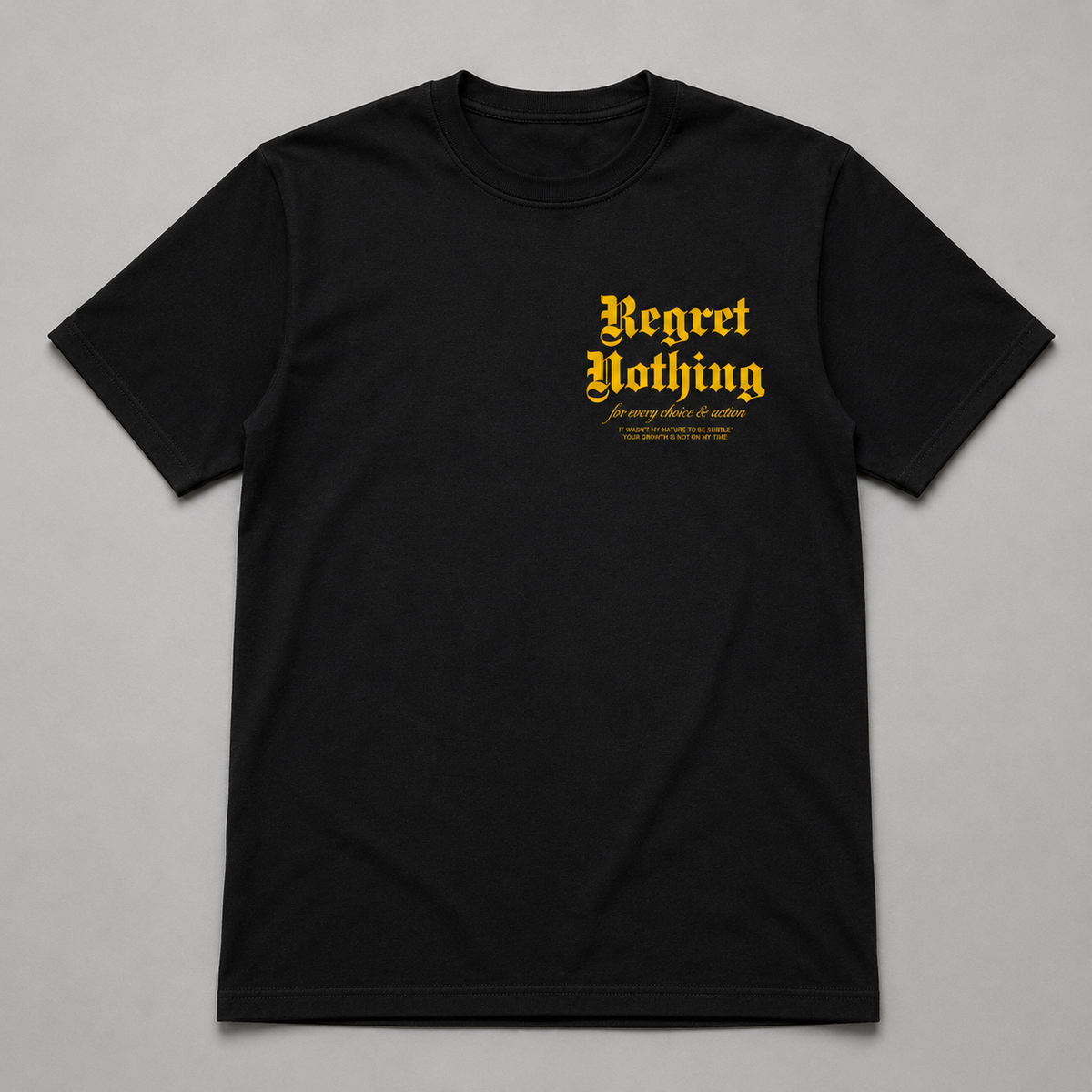 Black t-shirt with yellow text 'Regret Nothing' on a gray background