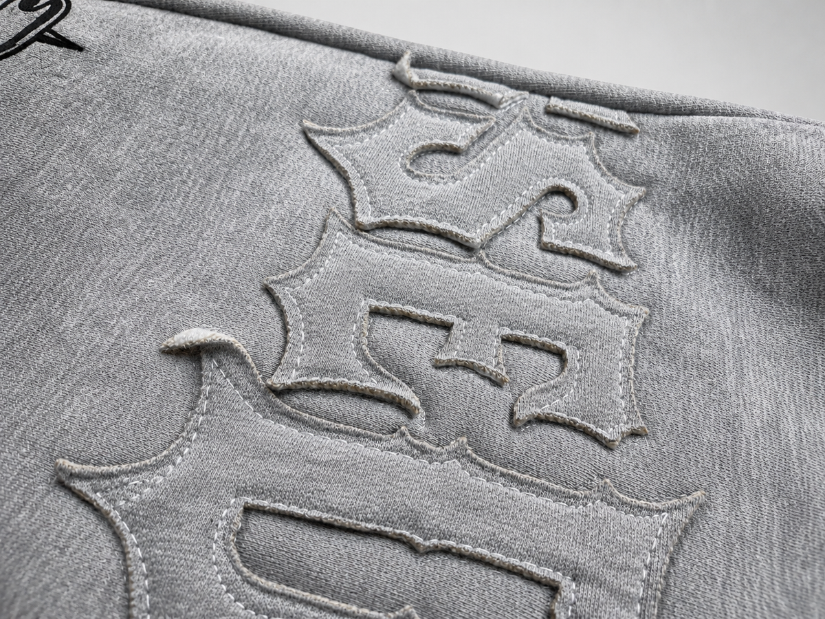 Close-up of a textured surface with embossed lettering on a gray background