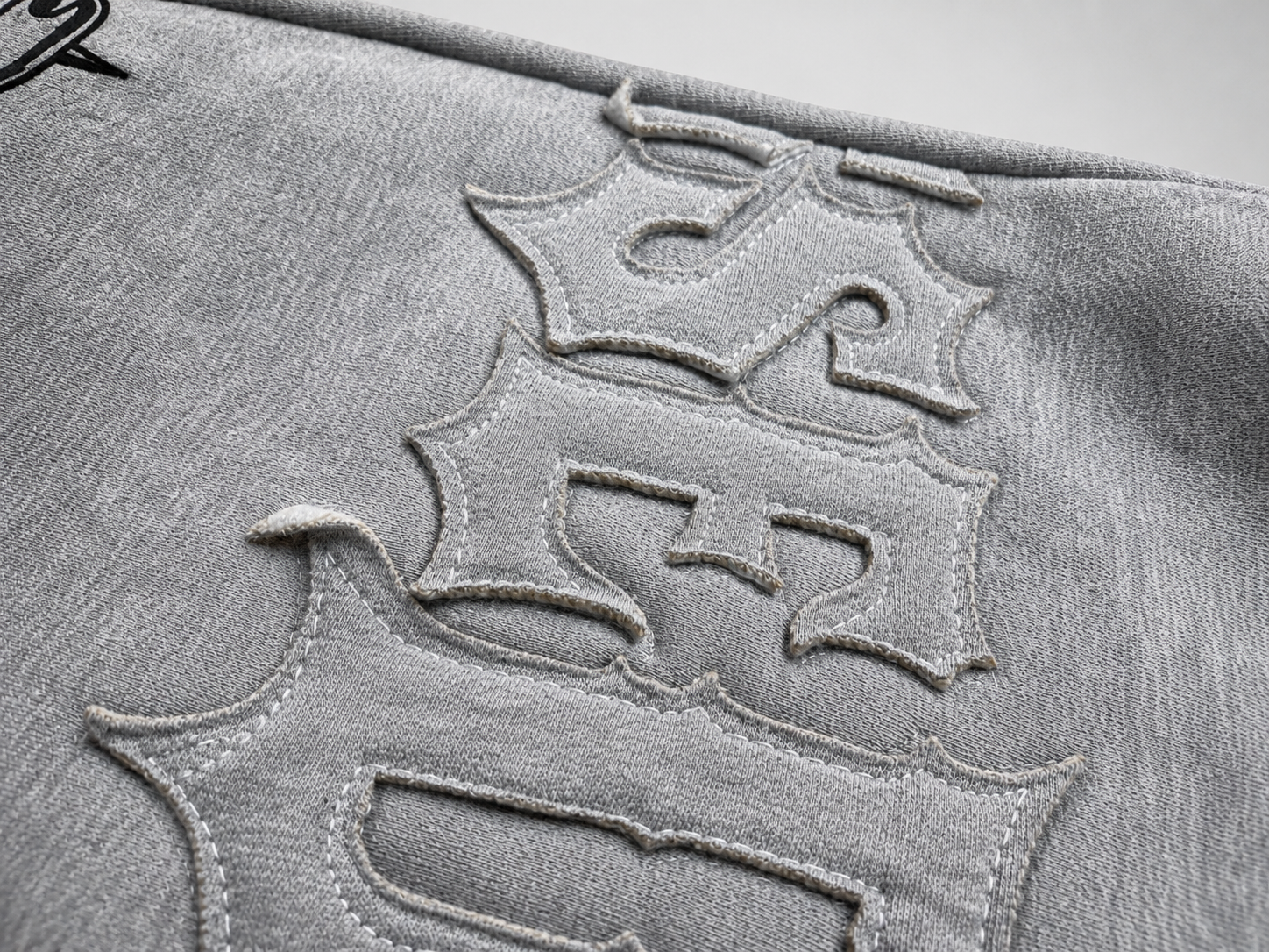 Close-up of a textured surface with embossed lettering on a gray background
